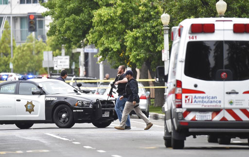 Fresno police members walk near a shooting scene Tuesday
