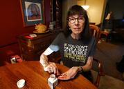 Gail Orcutt counts her medication at the kitchen table in her home