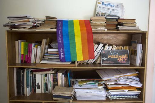 An LGBT pride flag hangs on a bookshelf by a Massimadi festival poster