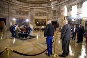 Military members practice placing a casket in the Rotunda of the Capitol