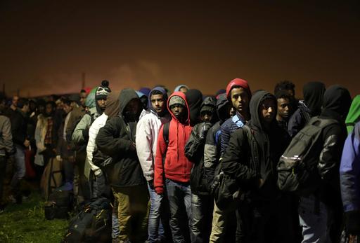 Migrants line-up to register at a processing centre in the makeshift migrant camp known as "the jungle" near Calais