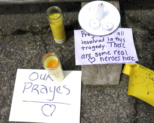 Well-wishing messages and candles for an injured employee are shown outside a grocery store in Estacada