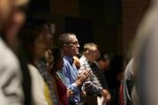 A man prays as he attends services for parishioners from flood-damaged St Ignatius Loyola Catholic Community Church in the auditorium of Klein High School Sunday
