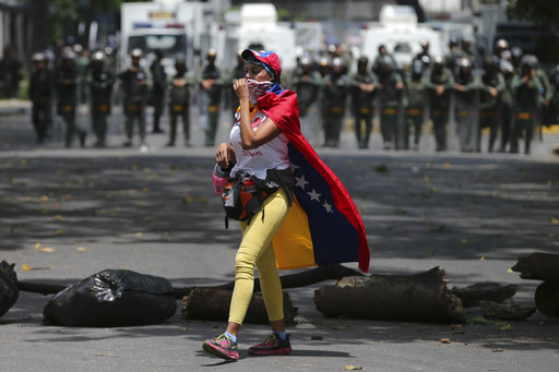 A demonstrator walks along a barricade set up during opposition protesters in Caracas
