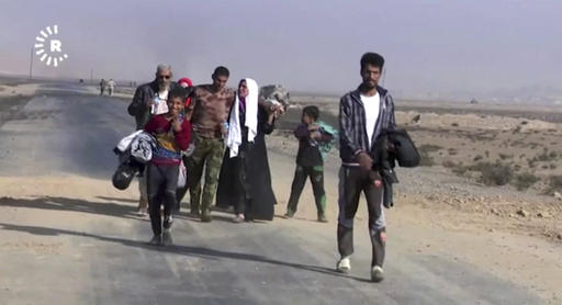 This image made from video by Rudaw News Agency shows a family fleeing Mosul