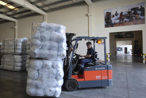 A lift truck driver uploads family tents for the Mosul refugees at the UNHCR warehouses