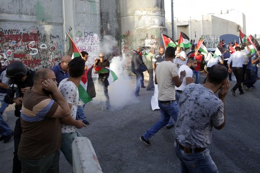 Palestinians run away from stun grenades thrown by Israeli border police officers during a protest against the metal detectors placed at the entrance to the Al Aqsa Mosque compound