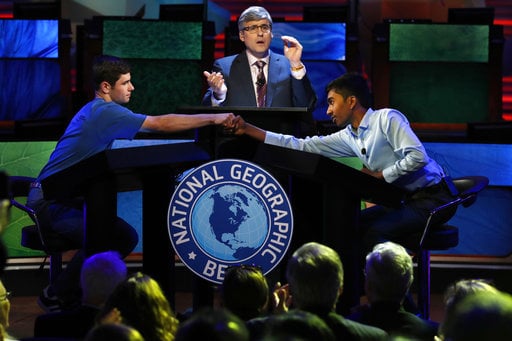 Host Mo Rocca applauds at center as Thomas Wright