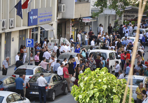 People gather outside an office building following an earthquake with a preliminary magnitude of 6.2 in the coastal city of Izmir
