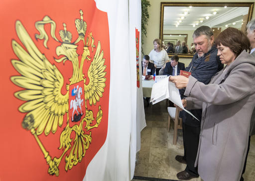 Russian citizens read their ballot papersat a polling station during parliamentary elections in the Russian embassy in Vilnius