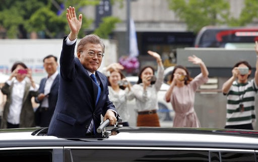 South Korea's new President Moon Jae-in waves from a car after his inauguration ceremony in Seoul