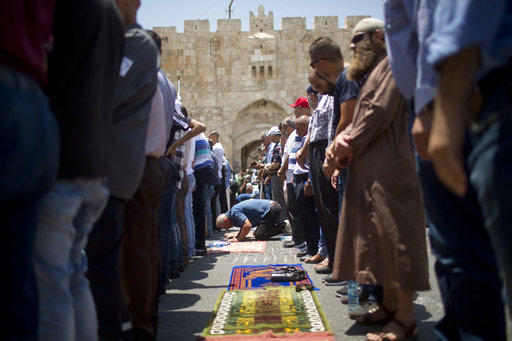 Palestinian Muslims pray outside the Lion's Gate following an appeal from clerics to pray in the streets instead of the Al Aqsa Mosque compound