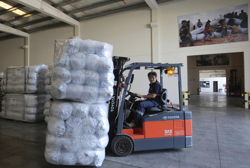 A lift truck driver uploads family tents for the Mosul refugees at the UNHCR warehouses