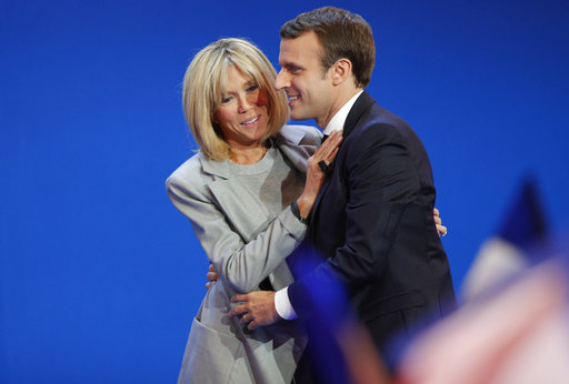 French centrist presidential candidate Emmanuel Macron and his wife Brigitte hug as he addresses his supporters at his election day headquarters in Paris