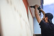 Cyber School Supply employee Christopher Rodriguez installs wood panels on windows in preparation in preparation for Hurricane Irma