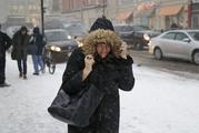 A woman walks through the snow and wind as she makes her way to the train station in Hoboken