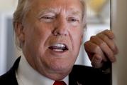 U.S. President Donald Trump speaks to reporters aboard Air Force One