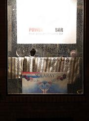 A broken window is seen at a business as protesters gather