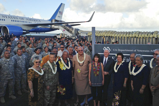 Vice President Mike Pence stands with his wife Karen as they pose for a photo with officials and U.S. service members during a refueling stop in Pago Pago