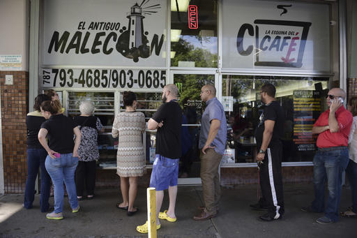 Customers stand in line at one of the few open cafeterias on Roosevelt Avenue