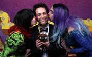 Actor Paul Rudd is kissed by actors dressed in drag as he accepts his pudding pot trophy at Harvard University in Cambridge