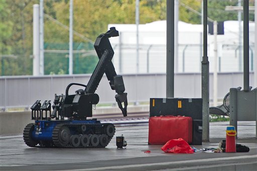 A remotely controlled bomb disposal robot approaches a red suitcase on a platform at the Chemnitz Central Station in eastern Germany