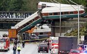 Cars from an Amtrak train lay spilled onto Interstate 5 below alongside smashed vehicles as some train cars remain on the tracks above Monday