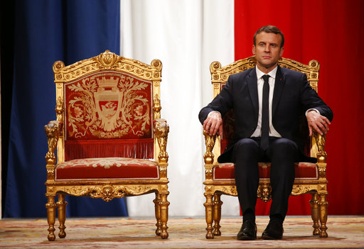 French President Emmanuel Macron listens as Paris Mayor Anne Hidalgo delivers her speech during a ceremony at the Hotel de Ville in Paris