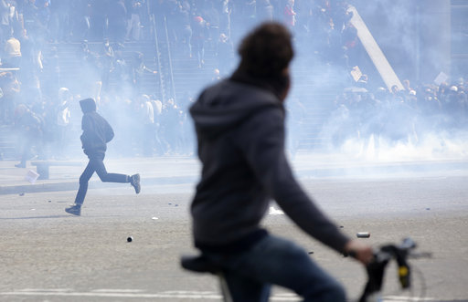 A youth runs during riots as part of the May Day demonstration