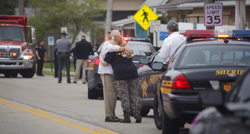 People hug as emergency personnel arrive to the scene of a shooting outside Pine Kirk nursing home in Kirkersville