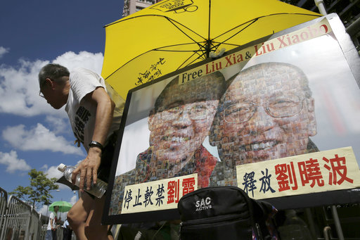 A protester displays a portrait of jailed Chinese Nobel Peace laureate Liu Xiaobo and his detained wife Liu Xia during a demonstration outside the Chinese liaison office in Hong Kong