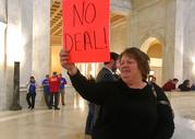 Sherman High School special needs teachers aide Belva Perry holds up a sign Wednesday