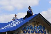 Los Angeles Dodgers fans take photos on a blue-painted single home roof