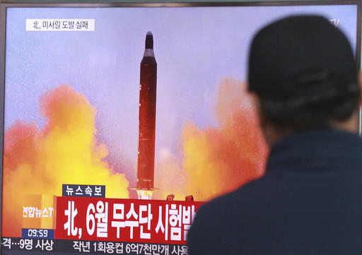 A man watches a TV news program showing a file image of a missile launch conducted by North Korea