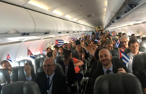 JetBlue flight 387 passengers hold up representations of Cuba's national flag