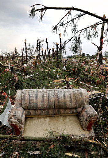 A sofa sits on damaged trees after a tornado ripped through Prairie Lake Estates trailer home park