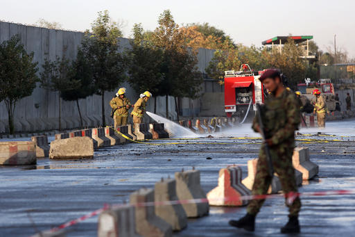 An Afghan soldier inspects the site of suicide attack In Kabul near Afghanistan's Defense Ministry