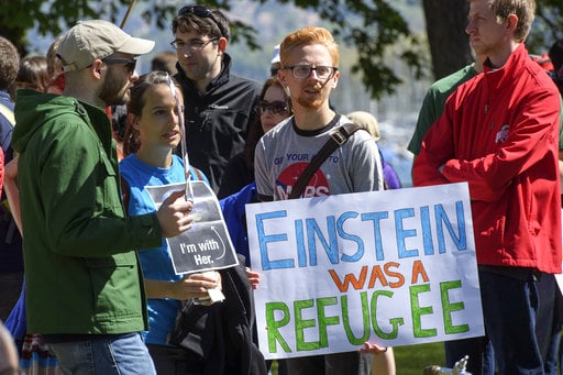 People stand together holding placards during the March for Science day in Geneva