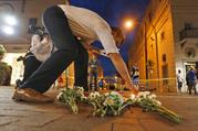 Charlottesville resident Elliot Harding lights a candle as he places flowers and a stuffed animal at a makeshift memorial for the victims after a car plowed into a crowd of people peacefully protesting a white nationalist rally earlier in the day in Charlottesville
