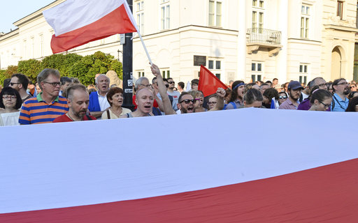 Anti-government protesters shout slogans as they gather in front of the presidential palace in Warsaw