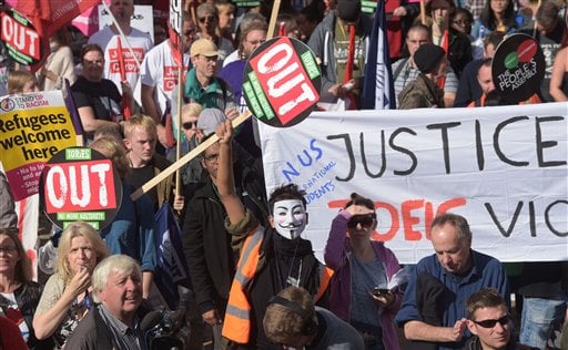 Protesters brandish various placards and signs as they gather at an anti-austerity demonstration outside the Conservative Party Conference in Birmingham