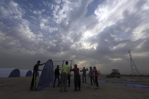 Workers set up a camp for displaced Iraqis in Khazer