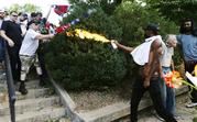 A counter demonstrator uses a lighted spray can against a white nationalist demonstrator at the entrance to Lee Park in Charlottesville