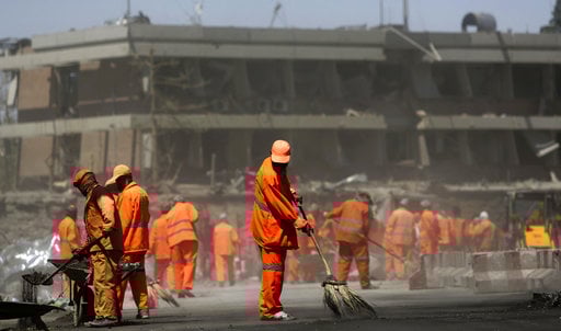Afghan Municipality workers sweep a road in front of the German Embassy after a suicide attack in Kabul