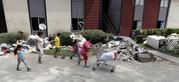 A family walks past debris from a flooded apartment complex in the aftermath of Hurricane Harvey Tuesday