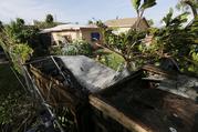 Bayardo Perez prepares to dismantle the mangled tin roof of his shed in Sweetwater