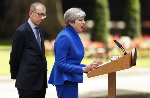 British Prime Minister Theresa May speaks watched by her husband Philip in 10 Downing street