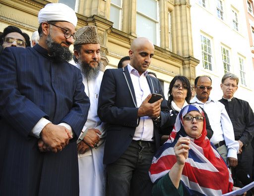 Religious leaders speak to crowds during a vigil at St Ann's square in central Manchester