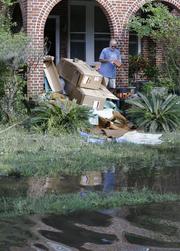 A home owner removes water logged items from his home as floodwaters fill the street in the San Marco area of Jacksonville