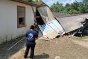 Silvia Casas tours the wreckage of their family home near the San Jacinto River in Crosby